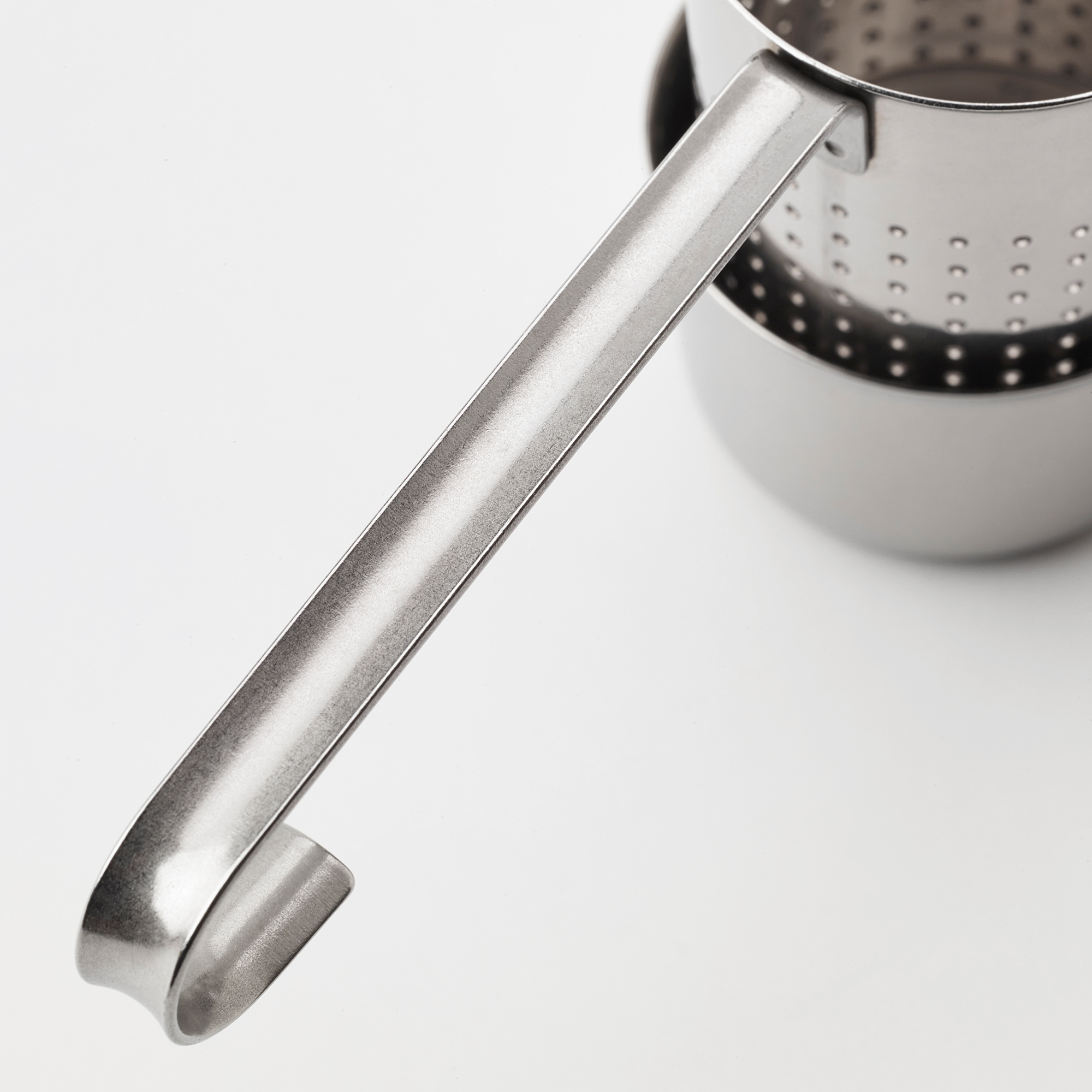 Close-up of sleek stainless steel tea infuser, showcasing its sturdy handle.