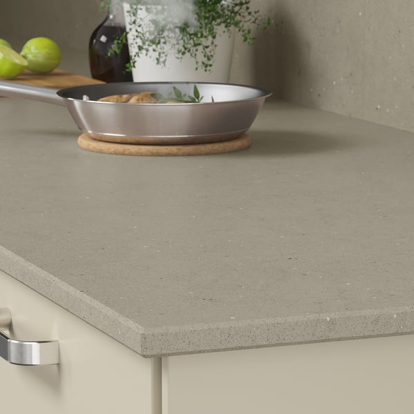 Kitchen counter with gray recycled glass worktop featuring a pan and limes.
