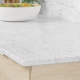 Image shows a sleek, white LOCKEBO recycled glass kitchen worktop with light gray veining, resistant to stains and moisture.