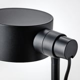 Black minimalist lamp with adjustable neck, mounted on a sleek stand.