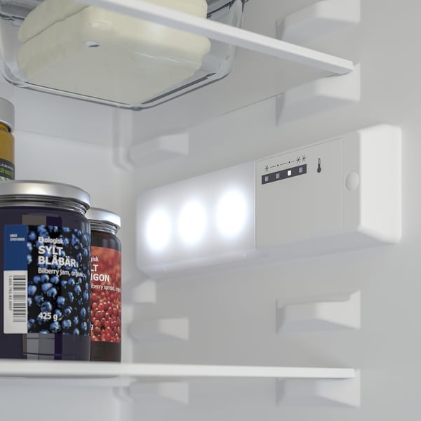 Fridge with led interior lights on, showing temperature controls and containers.