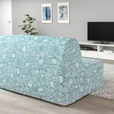 Modern living room with turquoise, white-patterned 2-seat sofa-bed, tv, art, plant.