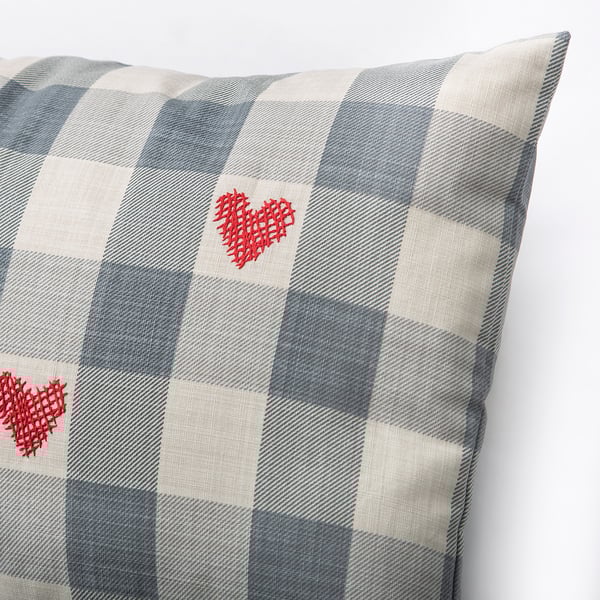 Checkered cushion with two red heart embroideries, showcasing high-quality craftsmanship and attention to detail.