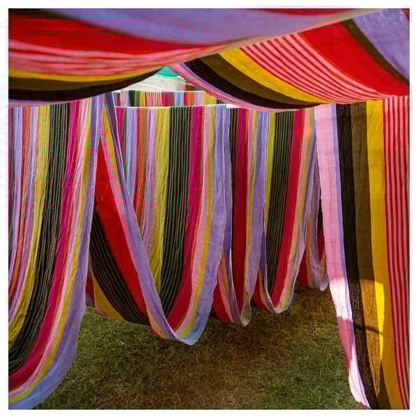 Vibrant striped fabric canopy, colorful horizontal lines, rectangle shapes, outdoor display, handwoven cotton.