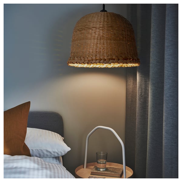Hanging pendant lamp MÄVINN above bedside table with book, glass, and light.