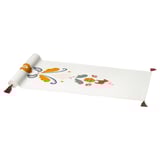 A white MÄVINN table runner with colorful, embroidered scandinavian patterns, featuring hearts and dala horses. It has tassels on either end.
