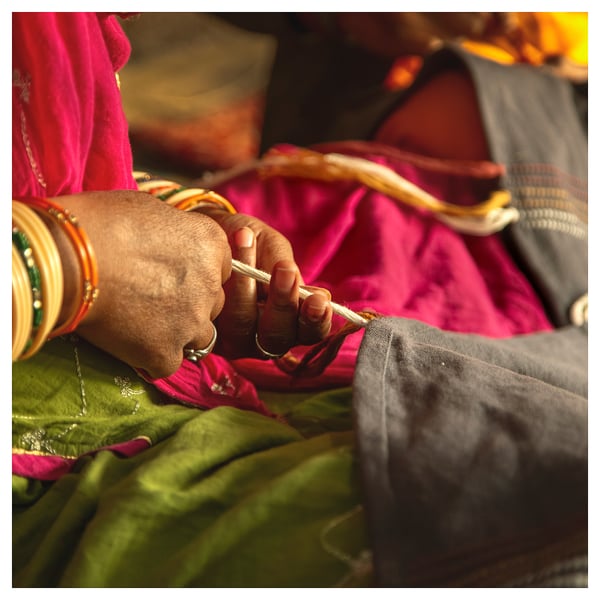 Hands weaving colorful threads, bangles & glove, traditional craft.