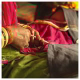 Hands weaving colorful threads, bangles & glove, traditional craft.