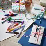 Colorful MÅLA pens and gift wraps with bright designs.