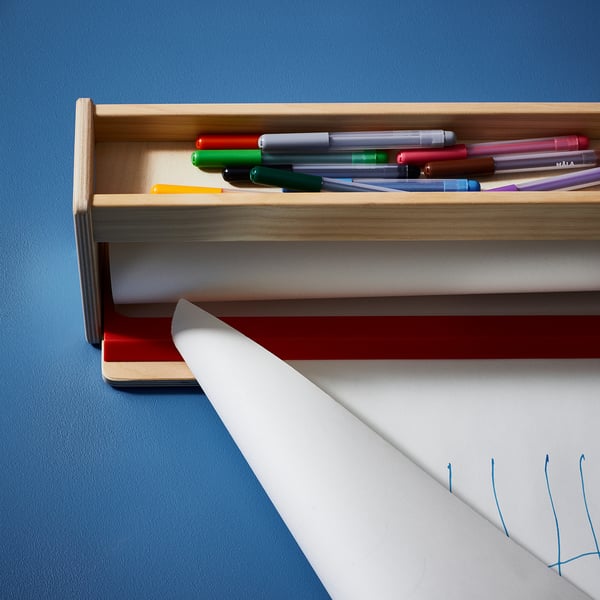 Wooden pen holder with colorful felt-tips and paper.