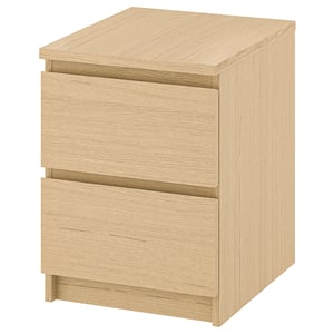 An ikea MALM light brown wooden nightstand with smooth drawers.
