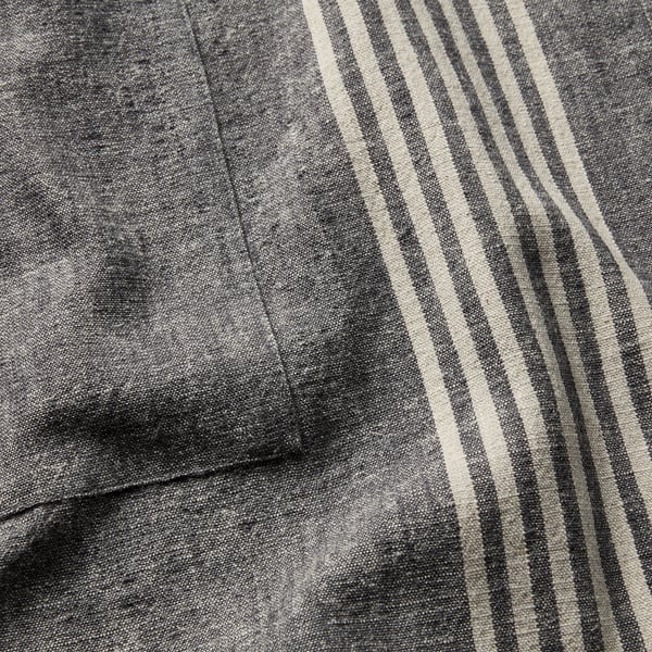 Close-up of striped linen-cotton apron fabric, showcasing texture and quality.