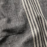 Close-up of striped linen-cotton apron fabric, showcasing texture and quality.