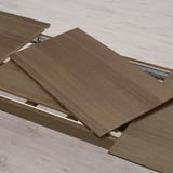 An extendable table section with one leaf pulled out, allowing for additional seating. Two leaves included for easy extension.