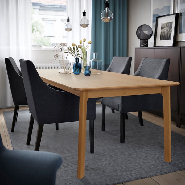Oak veneer MELLANSEL extendable dining table with 6-10 seats, grey chairs, rug, and pendant lights.