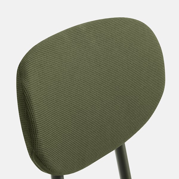 Chair backrest detail: dark green upholstery with textured weave pattern.
