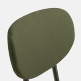 Chair backrest detail: dark green upholstery with textured weave pattern.