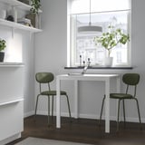 Minimalist home office with MELLTORP white table & green chairs, perfect for small spaces. Modern & sturdy with a clean design.