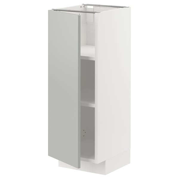 A white METOD kitchen cabinet with light grey door and shelf, featuring a modern minimal design.