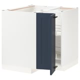 Displays a white and blue METOD kitchen cabinet set with an open door, revealing adjustable shelves and a corner carousel storage unit.