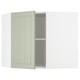 Light green METOD corner kitchen cabinet open, revealing shelves.