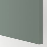 Smooth, modern teal kitchen cabinet close-up. High-quality finish, minimalist design. 25-year guarantee.