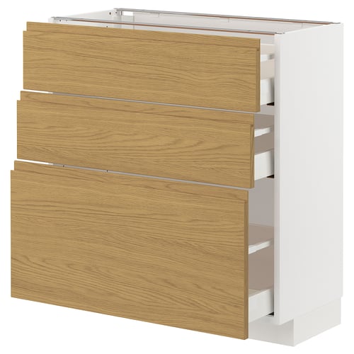 A white METOD kitchen cabinet with three light oak drawers and integrated handles. The design is minimalist and modern.