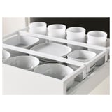 Open kitchen drawer showing organized white bowls and cups, part of METOD system.