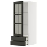 A modern, white METOD kitchen cabinet with black bodbyn glass doors. The cabinet includes two pull-out drawers and adjustable shelves.