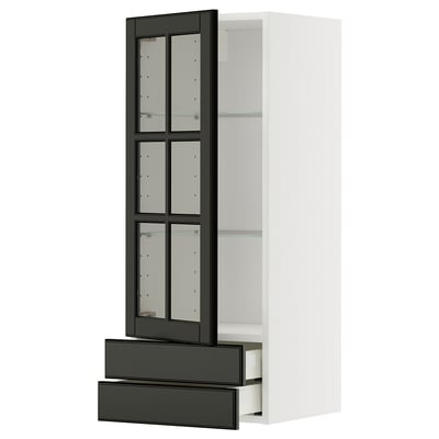 A modern, white METOD kitchen cabinet with black bodbyn glass doors. The cabinet includes two pull-out drawers and adjustable shelves.