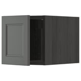 A dark grey IKEA METOD kitchen cabinet with a wooden look, featuring a single door with a recessed panel design.