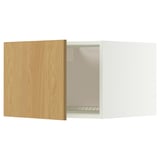 A white METOD kitchen cabinet with a light wood door slightly ajar. It a flat panel design and snap-on hinges.