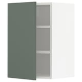 A greenish-grey METOD kitchen cabinet with two shelves and adjustable shelves. Its a modern, rectangular, wall-mounted design with a matte finish.