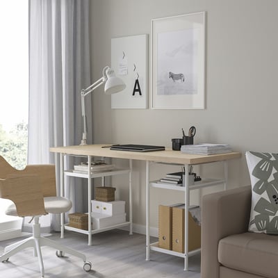 Modern workspace with MITTCIRKEL desk, chair, sofa, and lamp. Neatly organized with books and papers.