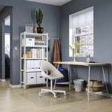 Home office with MITTCIRKEL desk, white chair, storage unit, and window; light wood floor.