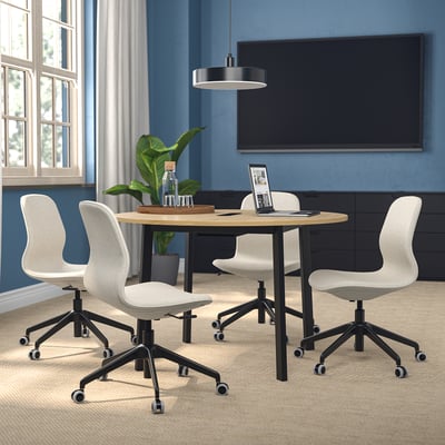 MITTZON conference table with white chairs in a cozy workspace with tv and window.