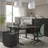 Modern home office setup with MITTZON black height-adjustable desk, green chair, and unique white pendant lamps. Clean, minimalist design.