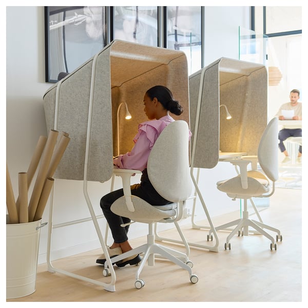 Woman in sound-insulated MITTZON office pod with laptop.