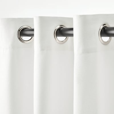 Two light-blocking curtains hang side by side, featuring silvery metal eyelets for easy rod installation, ensuring privacy and diffusing harsh light.
