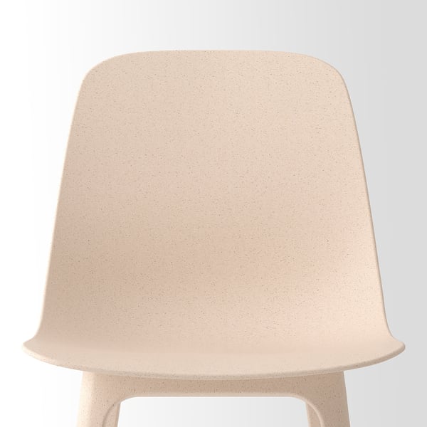 Beige chair with smooth, speckled texture, curved back and seat, set against white.