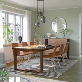 Modern dining set with wooden table and tan chairs, seated 6, under round lights.