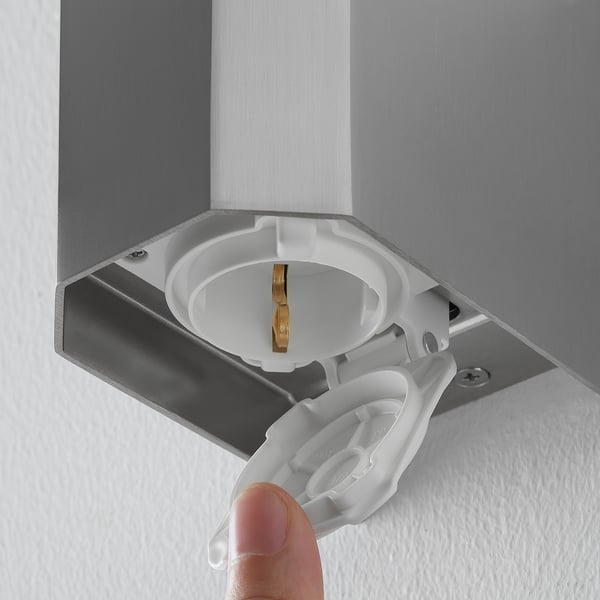 Image shows a close-up of an electrical socket on a wall lamp, indicating its dual functionality as a light fixture and power outlet.