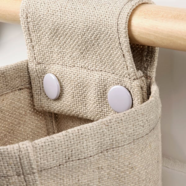 Close-up of natural fiber storage basket with sturdy wood pole and durable fabric.