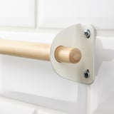 Close-up of high-quality wooden rod, securely mounted with white metal brackets using screws.