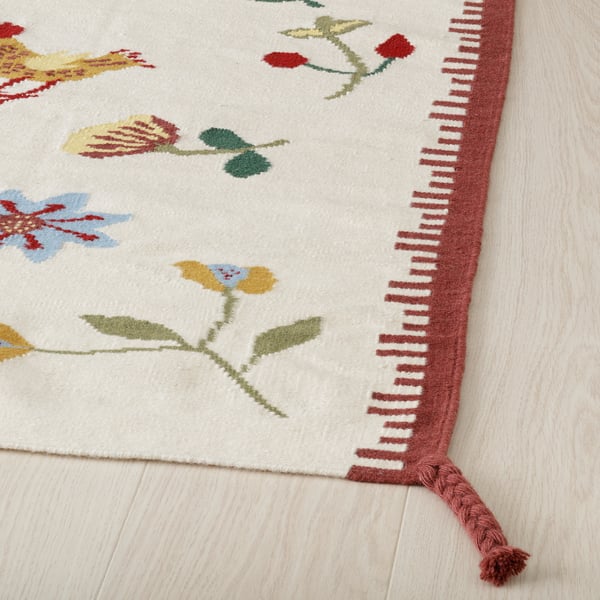 Brightly colored floral rug with intricate weaving and fringe detail. Vibrant and durable wool and cotton design.