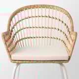 A well-crafted wicker chair with armrests, featuring intricate woven patterns and a cushioned seat, offering comfort and elegance.