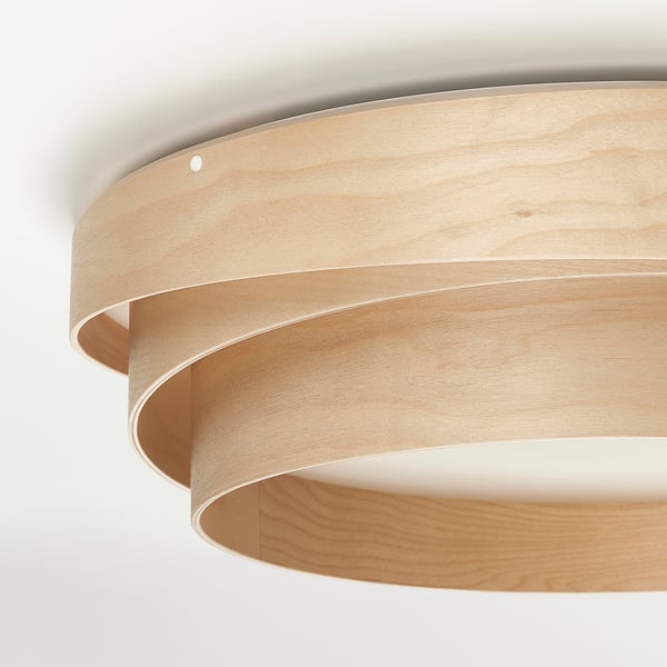 Modern circular wooden ceiling lamp with light diffusing through spaces between wood layers.