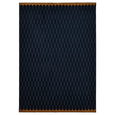 A NÖVLING rug in dark blue with a geometric pattern, made from recycled polyester, rectangular shaped with a scalloped border.