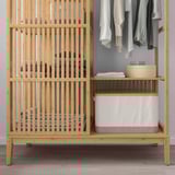 Wooden wardrobe with sliding door, shelves, and hanging space for clothes. It also includes storage containers for organizing items.