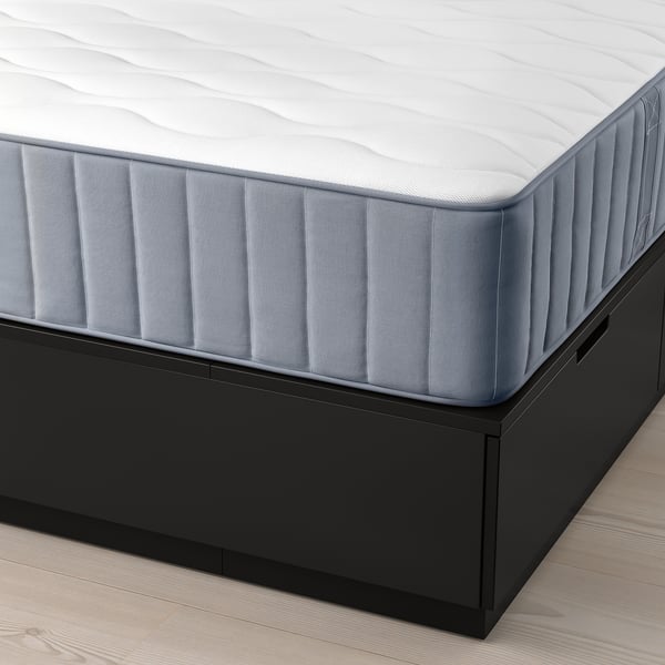 Image showing a NORDLI bed frame with drawers and a mattress. The bed has three large, soft-closing drawers underneath for storage.